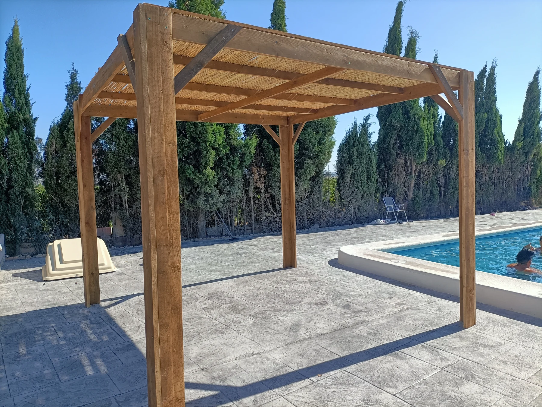 Pérgola de madera junto a una piscina