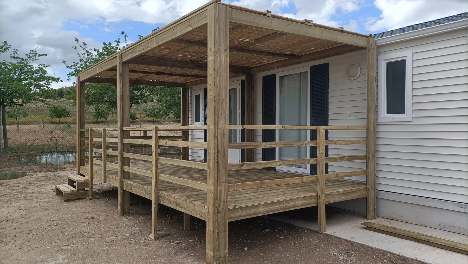 Terraza de madera con cubierta y barandilla